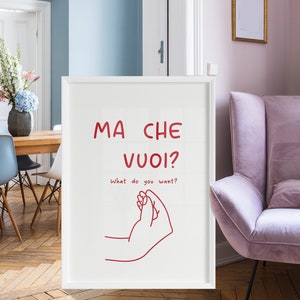 以下が含まれることがあります： 白い額縁に入ったプリントには、イタリア語で「Ma Che Vuoi?」と赤い文字で書かれており、英語では「What do you want?」という意味です。プリントには、赤い線で描かれた手のジェスチャーも含まれています。