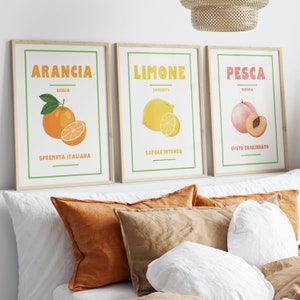 Może przedstawiać: Trzy oprawione wydruki z ilustracjami owoców. Pierwszy wydruk jest pomarańczowy i mówi "Arancia, Sicilia, Spremuta Italiana". Drugi wydruk jest żółty i mówi "Limone, Sorrento, Sapore Intenso". Trzeci wydruk jest brzoskwiniowy i mówi "Pesca, Verona, Gusto Equilibrato".