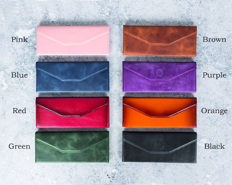 Pode incluir: Uma cole&ccedil;&atilde;o de oito carteiras de couro estilo envelope em v&aacute;rias cores, incluindo rosa, castanho, azul, roxo, vermelho, laranja, verde e preto. Cada carteira apresenta um design costurado e um fecho de aba. As cores s&atilde;o rotuladas com texto.