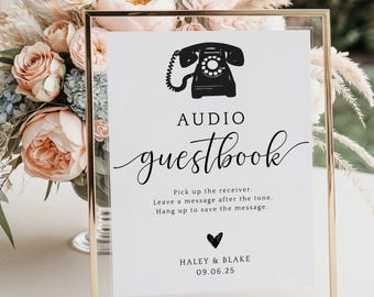 May include: A gold-framed sign with a white background and black text. The sign says "AUDIO guestbook" with a vintage phone graphic. The text below the phone says "Pick up the receiver. Leave a message after the tone. Hang up to save the message." The bottom of the sign says "HALEY & BLAKE 09.06.25".