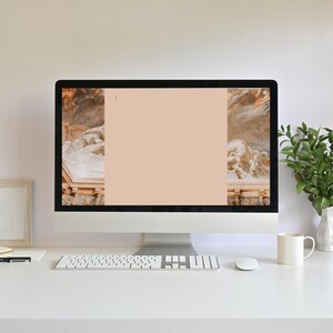 Puede incluir: Un ordenador de sobremesa moderno con teclado y rat&oacute;n blancos, y una pantalla en blanco con un fondo color melocot&oacute;n. La pantalla muestra obras de arte cl&aacute;sicas en los laterales. Una taza blanca, un jarr&oacute;n con hojas verdes y un marco de fotos est&aacute;n sobre el escritorio blanco.