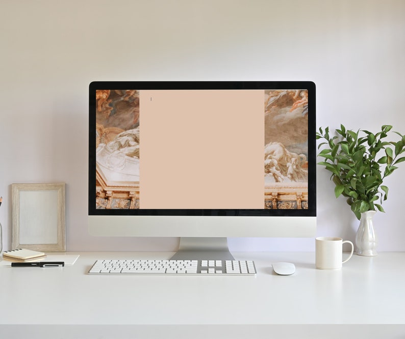 Puede incluir: Un ordenador de sobremesa moderno con teclado y rat&oacute;n blancos, y una pantalla en blanco con un fondo color melocot&oacute;n. La pantalla muestra obras de arte cl&aacute;sicas en los laterales. Una taza blanca, un jarr&oacute;n con hojas verdes y un marco de fotos est&aacute;n sobre el escritorio blanco.