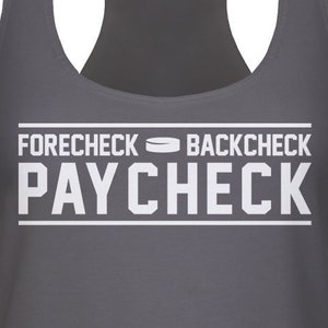 May include: A dark gray tank top with the text "FORECHECK BACKCHECK PAYCHECK" in white. A hockey puck icon is between the words "FORECHECK" and "BACKCHECK".