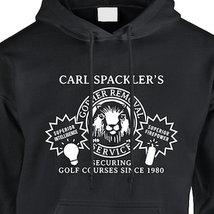 May include: Black hooded sweatshirt with a white graphic design featuring the text "Carl Spackler's Gopher Removal" and a cartoon gopher. The graphic also includes the text "Superior Intelligence", "Superior Firepower", "Service", and "Securing Golf Courses Since 1980".
