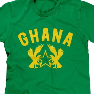 Puede incluir: Camiseta verde con la palabra "GHANA" en letras amarillas y una estrella amarilla con dos p&aacute;jaros amarillos a cada lado.