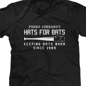 May include: Black t-shirt with white text that reads "Pedro Cerrano's Hats For Bats Keeping Bats Warm Since 1989" and a white baseball bat graphic.
