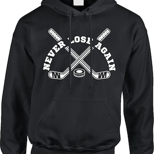 May include: Black hooded sweatshirt with a white graphic of two hockey sticks crossed over a puck with the text "Never Lose Again".