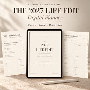 May include: A digital planner titled The 2027 Life Edit displayed on a tablet screen, flanked by two open pages showing a 2027 Life Dashboard and a Monthly Dashboard. A white stylus rests in front of the tablet on a textured surface.