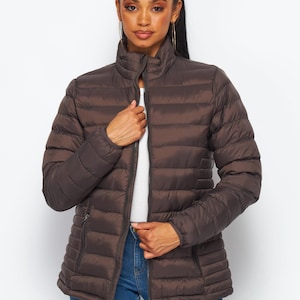 May include: A brown quilted puffer jacket with a zipper closure and a stand-up collar.