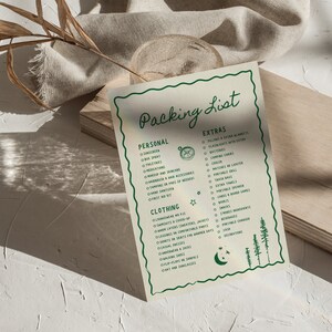 May include: A green and white printable packing list for camping trips. The list includes categories for personal items, clothing, and extras. The list is decorated with a compass, stars, and a crescent moon.