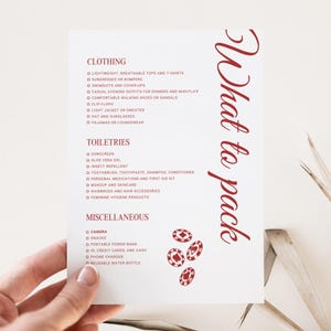 May include: A white checklist with red text titled "What to pack" with a list of items to bring for a trip. The list is divided into three categories: Clothing, Toiletries, and Miscellaneous. The list includes items such as lightweight tops, sunscreen, insect repellent, snacks, and a portable power bank.