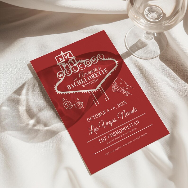 May include: Red invitation with white text for a bachelorette party in Las Vegas. The invitation features a stylized image of the "Welcome to Fabulous Las Vegas" sign with dice and playing cards. The text reads "Welcome to Amanda's Bachelorette Weekend, October 4-6, 202X, Las Vegas, Nevada, The Cosmopolitan, 3708 Las Vegas Blvd S, Las Vegas."