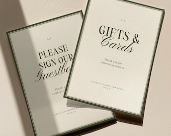 May include: Two rectangular wedding signs with a cream background and dark green borders. One sign reads "PLEASE SIGN OUR Guestbook" and the other says "GIFTS & Cards". Both signs include event details.