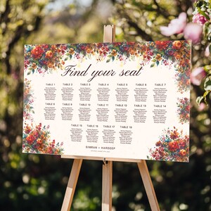 May include: A wedding seating chart on a wooden easel. The sign features a floral border with the words "Find your seat" at the top. The names of guests are listed under table numbers 1-19.
