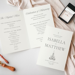 May include: A wedding programme for Isabella and Matthew featuring a church illustration, a black ring box with a ring, two gold rings, and two wax seal stamps. The programme text includes The Nuptial Mass, Celebration of Matrimony, and order of service.
