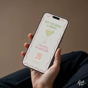 Op de afbeelding: Een smartphone toont een digitale uitnodiging voor een vrijgezellenfeest. De uitnodiging bevat een margarita-illustratie, de tekst "KOOP DE BRUID EEN DRANKJE!" en "Cassidy's Bachelorette" in roze, plus een QR-code.