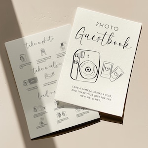 May include: Two cream-coloured photo guestbook cards. One card has instructions for taking photos and selfies. The other card has the words "Photo Guestbook" and a camera illustration. The text reads, "Grab a camera, strike a pose, and share your love for the new Mr. & Mrs."