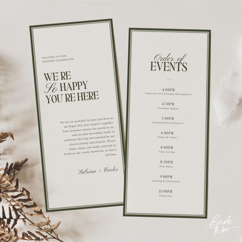 May include: Two wedding stationery cards with dark green borders. One card reads "We're so happy you're here" and the other lists the order of events. The cards are light beige with dark green text.