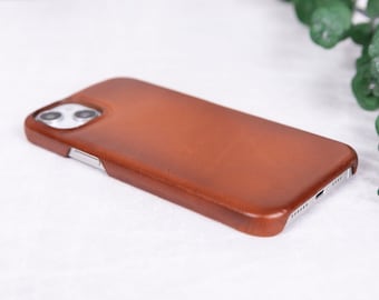 May include: A brown leather phone case for an iPhone.