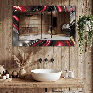 May include: A rectangular bathroom mirror with a decorative border featuring a red, black, and gold marbled design. The mirror reflects a bathroom with a wooden wall, a white sink, and a hanging plant.