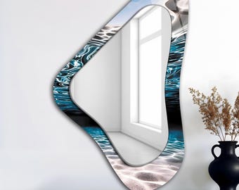 May include: An abstract-shaped wall mirror with a water-themed design. The mirror's frame features a blue and black water pattern, with a sky and water scene reflected in the glass. The mirror is displayed on a wooden surface.
