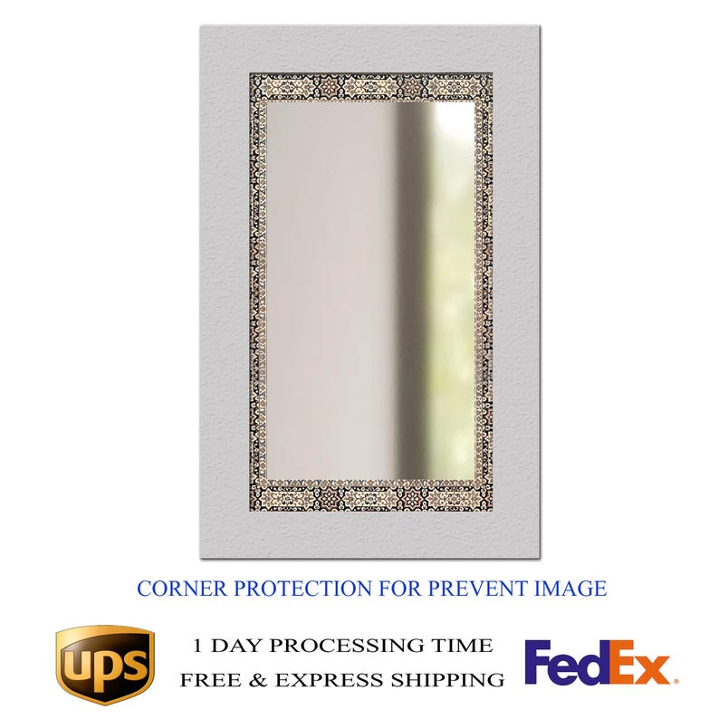 May include: Rectangular mirror with a white textured frame and a decorative border. The border features a repeating pattern in shades of beige, brown, and black. The text "CORNER PROTECTION FOR PREVENT IMAGE" is visible at the bottom.