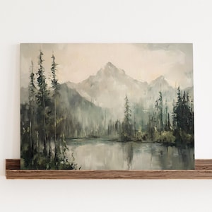 May include: A rectangular canvas painting depicting a misty mountain landscape with a calm lake in the foreground and tall, dark evergreen trees along the shoreline. The color palette features muted tones of grey, sage green, and soft beige.