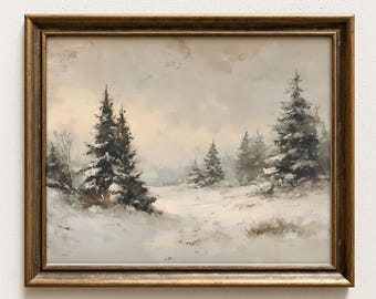Puede incluir: Un cuadro de paisaje enmarcado que representa una escena invernal nevada con árboles de hoja perenne bajo un cielo gris y nublado. La obra está enmarcada en metal dorado oscuro con acabado texturizado, mostrando una paleta de colores suaves en blanco, gris y verde oscuro.