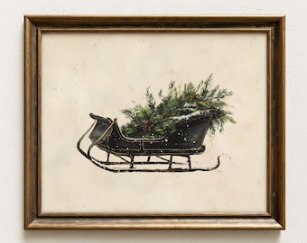 May include: A framed wall art print featuring a black sleigh filled with green pine branches and a light dusting of white snow. The artwork is encased in a metallic gold frame with a simple, clean design, set against a neutral off-white background.