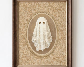 Könnte beinhalten: Ein gerahmter Kunstdruck mit einer weißen Geisterfigur aus Spitze, die in einem ovalen Rahmen zentriert ist. Der Hintergrund zeigt ein verziertes florales Damastmuster in Beige und Hellbraun. Das Bild ist in einem dunkelbraunen Holzrahmen gefasst.