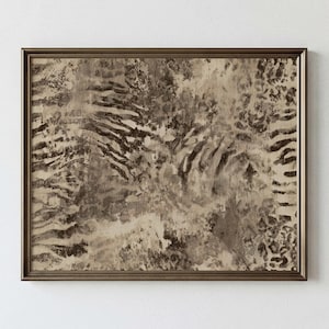 May include: A rectangular wall art piece in a metallic bronze frame featuring an abstract print with layered textures in shades of beige, taupe, and dark brown. The design incorporates blended patterns resembling animal stripes and spotted markings.