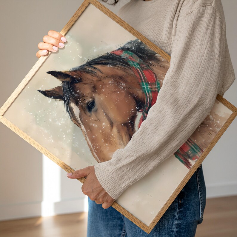 Vintage style horse wearing a red and green tartan bow with snow falling on a beige background, rustic printable farmhouse Christmas wall art.