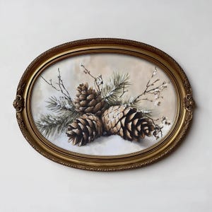 May include: An oval-shaped painting in an ornate gold frame depicting three brown pinecones nestled among green pine needles and bare twigs with a light dusting of white snow against a soft, neutral-toned, cream-colored background.