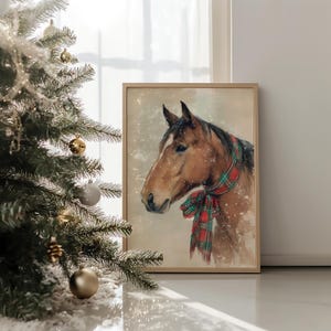Vintage style horse wearing a red and green tartan bow with snow falling on a beige background, rustic printable farmhouse Christmas wall art.