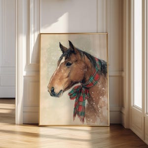 Vintage style horse wearing a red and green tartan bow with snow falling on a beige background, rustic printable farmhouse Christmas wall art.