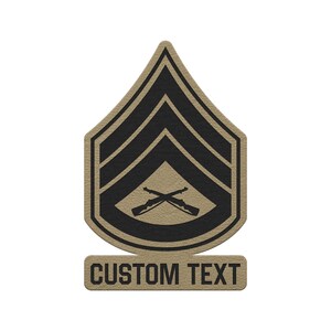 May include: A tan and black military-style rank patch featuring a chevron design with two crossed rifles in the center. Below the main shield-shaped emblem is a rectangular tab with the black text CUSTOM TEXT printed in a bold sans-serif font.