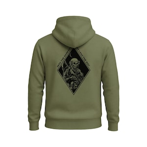May include: Olive green hoodie with a black graphic on the back. The graphic is a skull in a diamond shape, with the text "INTO THE DARKNESS WE LEAD THE WAY". The hoodie has a hood and a kangaroo pocket.