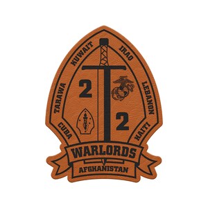 May include: A brown leather patch with a black sword design, the number 2, and the words "WARLORDS" and "AFGHANISTAN." The patch also includes the names of several countries and a military emblem.