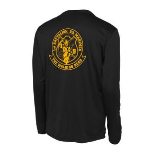 May include: Black long-sleeve shirt with a gold graphic of a skull and crossbones with the text "1st Battalion 9th Marines The Walking Dead".