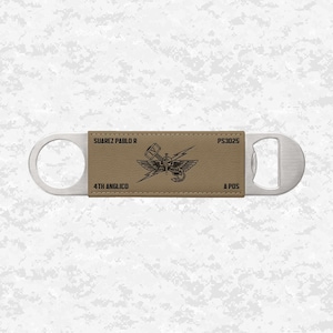 May include: A stainless steel bottle opener with a tan leatherette center. The leatherette features the text "SUAREZ PABLO R", "4TH ANGLICO", "PS3025", and "A POS", along with a graphic of a winged emblem.