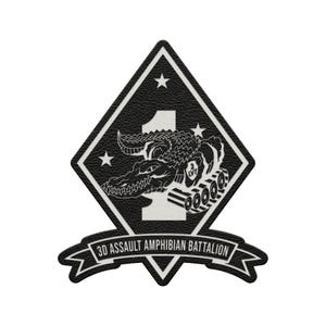 May include: A diamond-shaped black and white patch featuring a large number 1 in the background. An alligator is depicted over the number, with a small tank tread visible. Three stars are present, and a banner reads 3D ASSAULT AMPHIBIAN BATTALION.