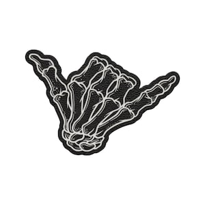 May include: Black and white patch featuring a skeleton hand in the shaka sign. The patch has a textured black background with a white outline of the hand bones. The design is a unique and edgy accessory.