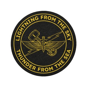 May include: A round, black patch with gold lettering and a central emblem. The text reads "LIGHTNING FROM THE SKY" and "THUNDER FROM THE SEA". The emblem features a winged sword, lightning bolts, and a hammer.