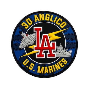 May include: A circular patch featuring the text 3D ANGLICO and U.S. MARINES in yellow lettering. The center displays a red LA logo, a grey fighter jet, a grey naval ship, and a yellow lightning bolt against a black and blue background.