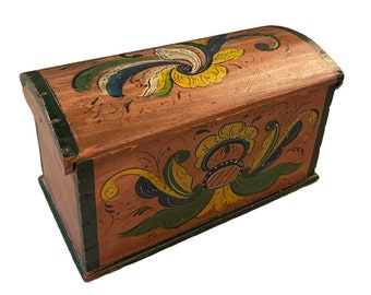 May include: A small wooden box with a curved lid, painted in a traditional folk art style. The box is decorated with floral motifs in shades of green, yellow, blue, and red.