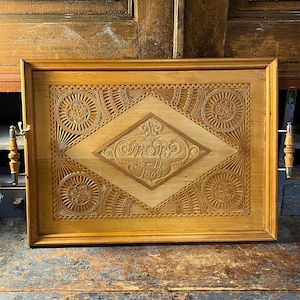 May include: A wooden serving tray with intricate carvings and a diamond-shaped design in the center. The tray has two wooden handles and the date "30-11-1908" is carved into the center.