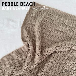 May include: A beige crocheted baby blanket with a textured pebble stitch pattern. The blanket is folded and draped over a white surface. The text "PEBBLE BEACH BABY BLANKET crochet pattern" is visible in the top left corner of the image.