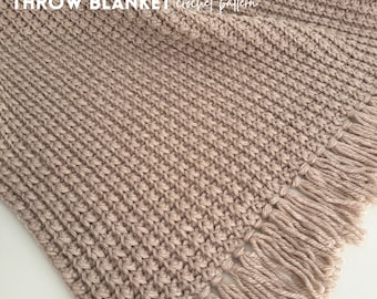 Może przedstawiać: Beżowy koc Rustic Ridge z teksturowanym wzorem szydełkowym i frędzlami. Koc zawiera tekst "RUSTIC RIDGE THROW BLANKET crochet pattern" w lewym górnym rogu i "LOOPED WITH LOVE" w prawym dolnym rogu.