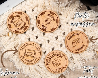 May include: Five wooden round tokens with different designs and text. The tokens feature a bear, headphones, a game controller, and a tablet. The text on the tokens includes "Medienzeit", "15 Minuten", "Hörspiel", "1 Folge", "Cassandras Tablet", "25 Minuten", "Eriks Cartoons", "1 Folge", "Screen Time", "5 Minuten".