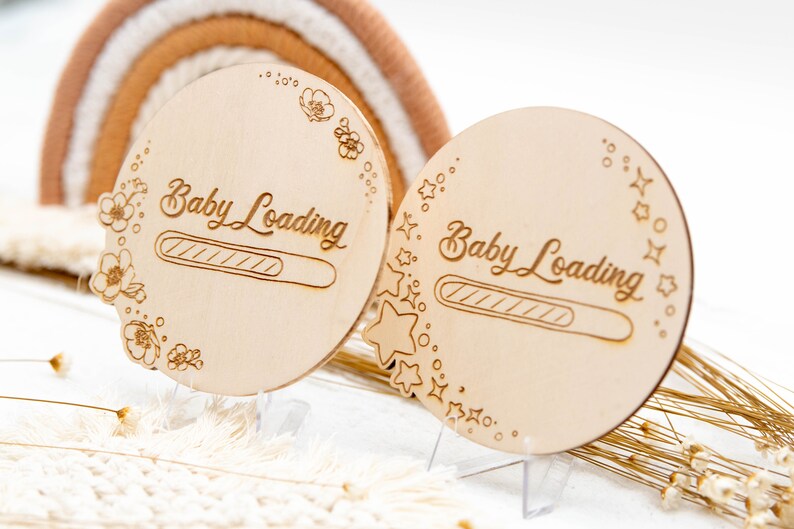 May include: Two wooden signs with the text "Baby Loading" and a progress bar. One sign is decorated with flowers and the other with stars.